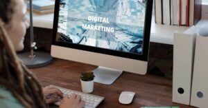 Close-up of a woman working on a digital marketing project in a home office setting.